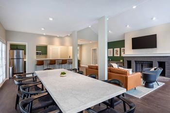 A dining room table and living room with a fireplace